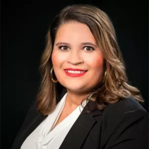 Dr. Diane Lira Smiling wearing a suit with a black background