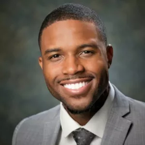 Charles Clancy Smiling Wearing a Suit